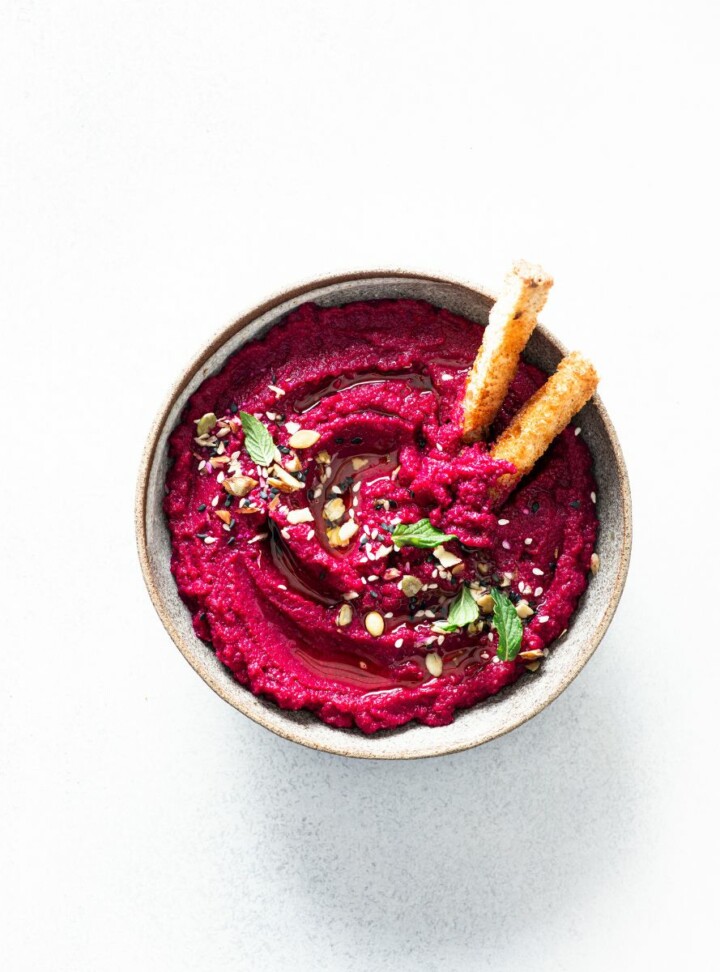lemon beet hummus with a toasted baguette in a bowl