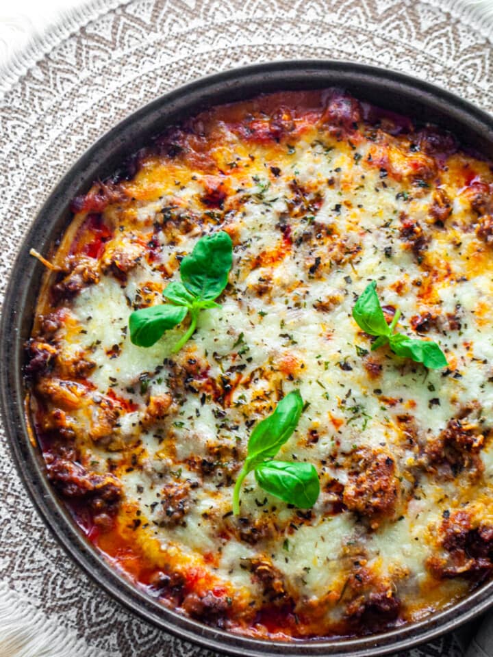 lasagna with a round dish and basil leaves on the top